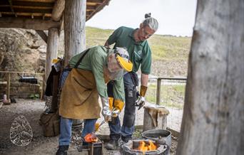 Workshop leader instructing participants when pouring molten bronze into a cast