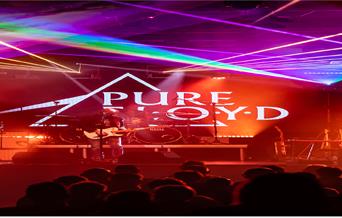 A concert with red and neon lighting. Logo of a triangle with the words 'Pure Floyd'.
