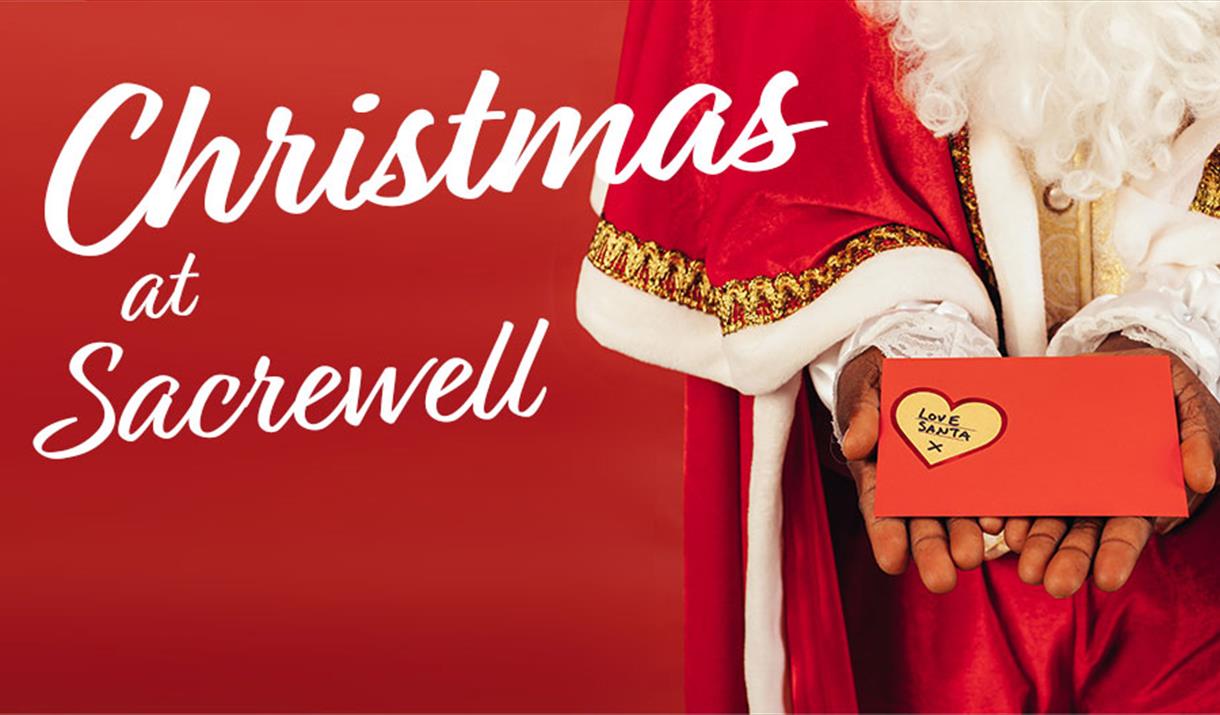 Christmas at Sacrewell - Santa holding gift.