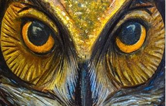 A close-up painting of an owl's eyes and beak