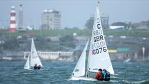 Sailors in a boat on the water with Smeaton's Tower in the background on the left 