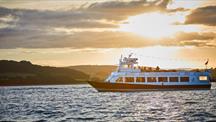 Passenger boat cruising on Plymouth waters at sunset.