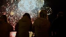 Young people look on at fireworks in the background