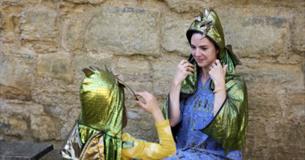A woman and a child dressed in green dragon costumes