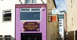 The purple painted outside of Fortune Court showing the entrance and adjacent alleyways.