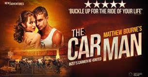 Man and Woman embrace, looking towards camera. The backdrop is steamy and orange.