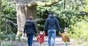 A family of four enjoy walking through Saltram garden completing their Easter trail with bunny ears on their heads.