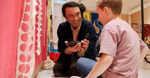Artist Huhtamaki Wab with a young child at a workshop event