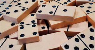 A pile of white dominoes with black dots