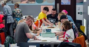 Photograph showing a busy workshop of families making craft activities