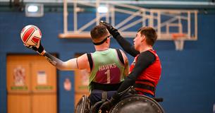 Two wheelchair rugby players battle to win the ball