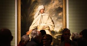 visitors viewing a painting at Journeys with Mai exhibition