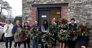 A few members from the Pentillie team holding Christmas wreaths they had made they had just made.