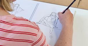 A woman takes part in a life drawing workshop