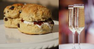 Scones with jam and cream and two glasses of prosecco