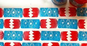 Block-printed blue and red Christmas crackers on wrapping paper