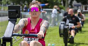 Man rowing on a rowing machine with others behind him.