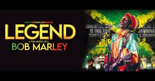 Title of Bob Marley in Jamaican colours on a back background with him singing into the microphone with back up singers in the background