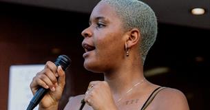 Woman with microphone. Photo Credit: Aiden Craver