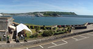 Dutton's Café and garden with views of Turnchapel, Mountbatten, Plymouth Sound and the Breakwater in the background.