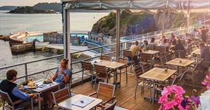 The Terrace's under cover outside seating area with customers eating and drinking. Beautiful views of Drake's Island and Tinside Lido.