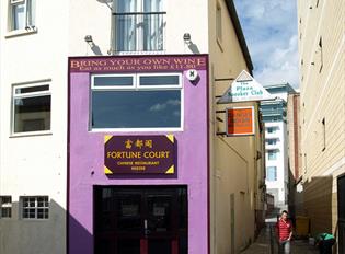 The purple painted outside of Fortune Court showing the entrance and adjacent alleyways.