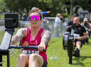 Man rowing on a rowing machine with others behind him.