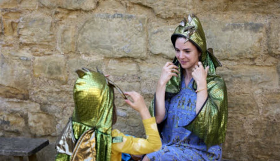 A woman and a child dressed in green dragon costumes