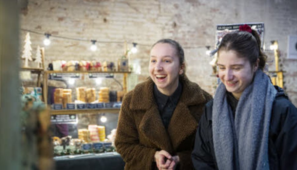 Visitors exploring an indoor Christmas market