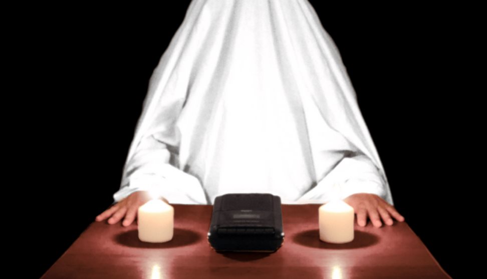 a ghost sits at a table with candles. Text reads 'is anybody there?'