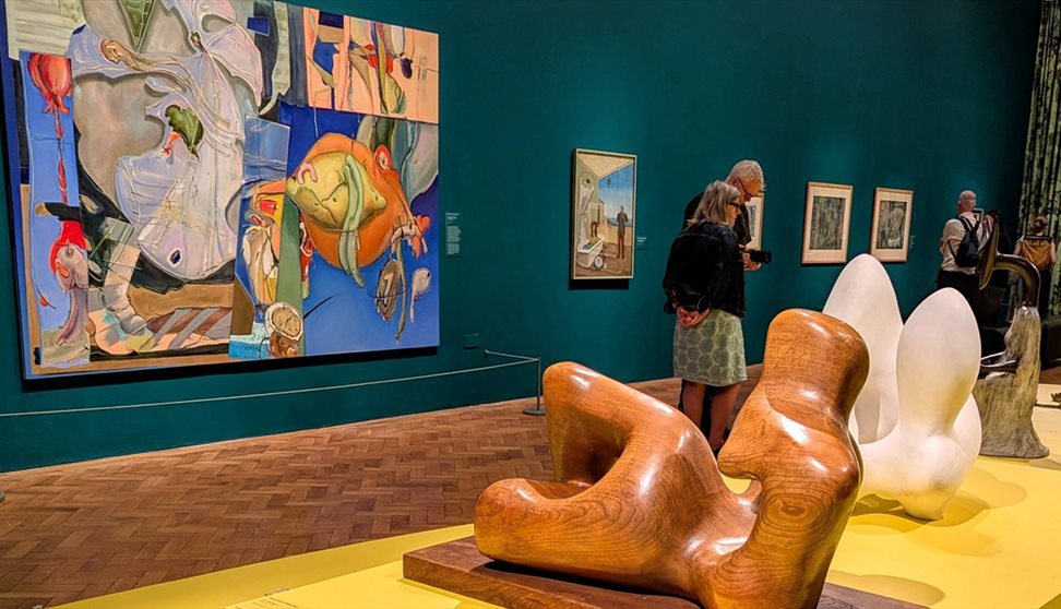 Photograph showing visitors looking at sculpture in an exhibition.
