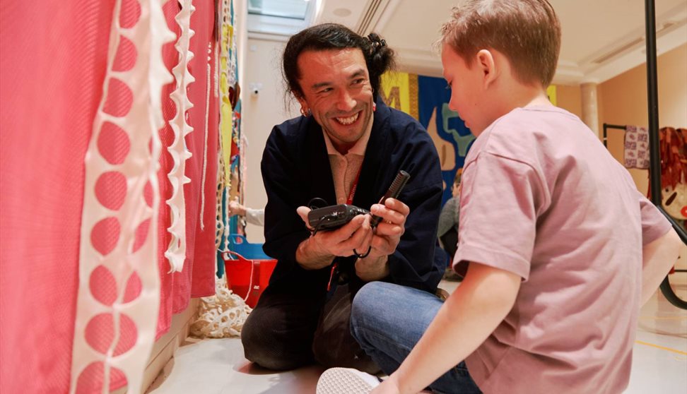 Artist Huhtamaki Wab with a young child at a workshop event