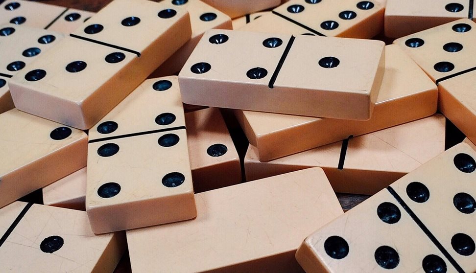 A pile of white dominoes with black dots
