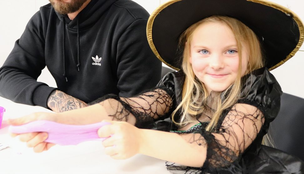 A girl in a witch's hat and Halloween costume