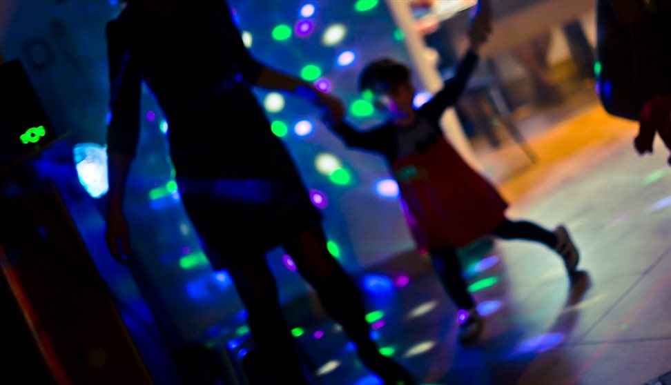 Photograph showing a parent and child at a disco