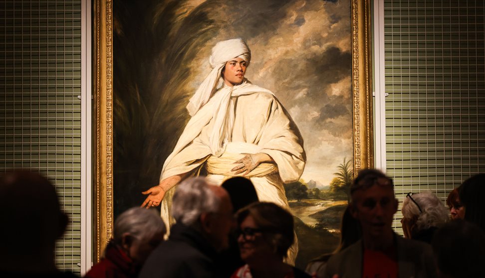 visitors viewing a painting at Journeys with Mai exhibition