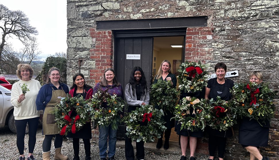 A few members from the Pentillie team holding Christmas wreaths they had made they had just made.