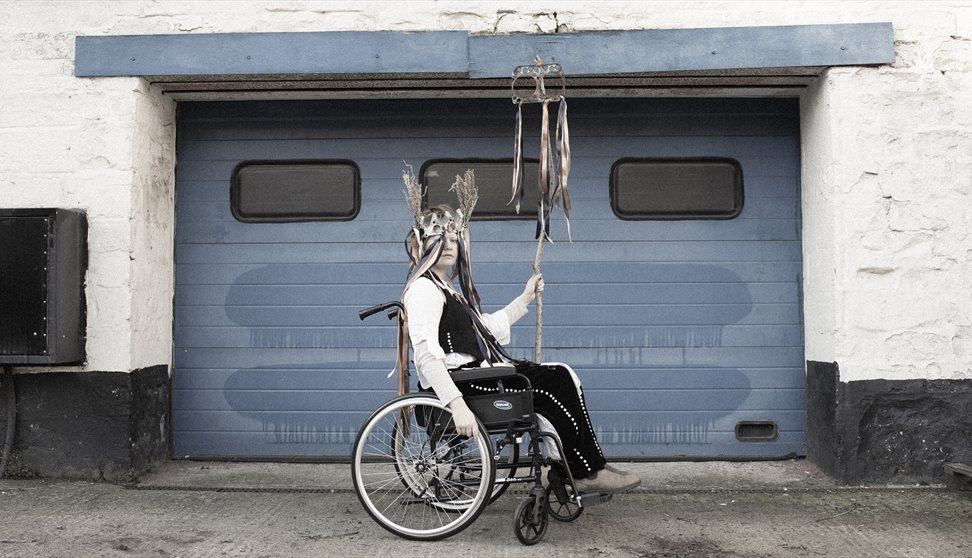 libby bove sitting in a wheelchair in front of a garage doot