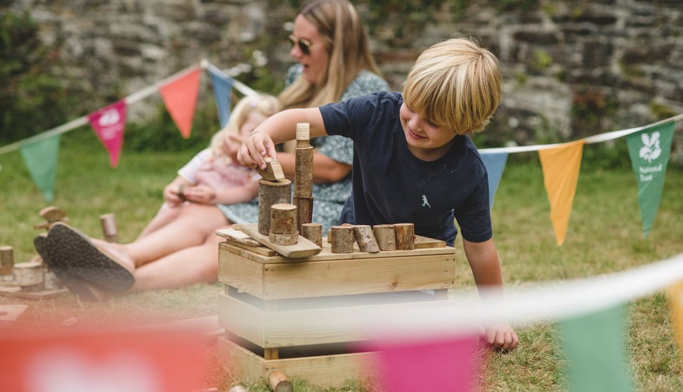 A child playing with wooden blocks surrounded by colourful bunting