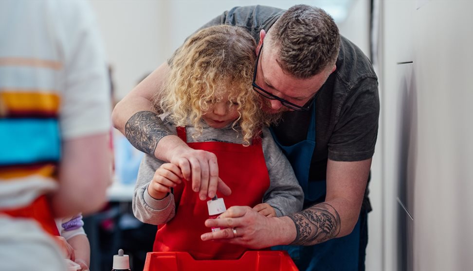 A girl and her dad take part in a creative workshop at The Box