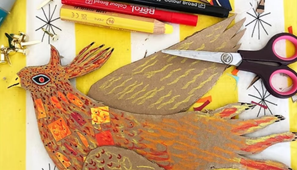 A cardboard phoenix on a crafting table
