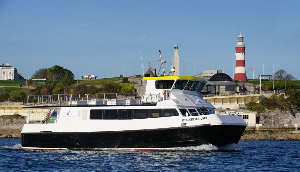 Plymouth Venturer at sea with Plymouth Hoe backdrop