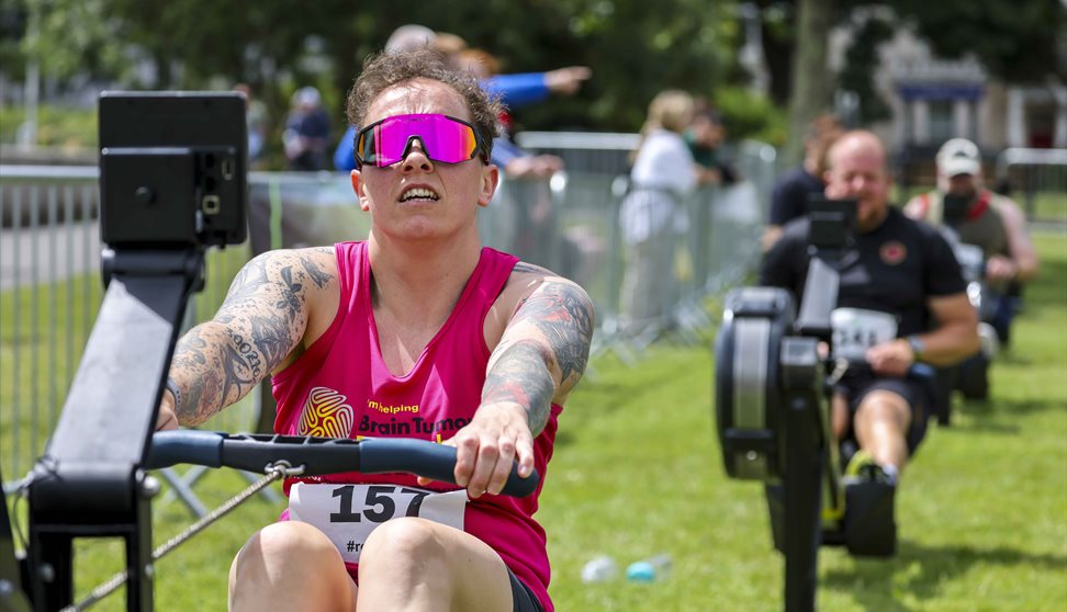 Man rowing on a rowing machine with others behind him.