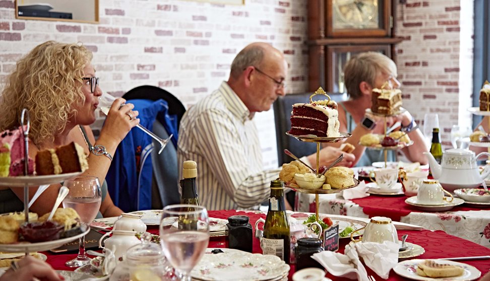 People sat at tables inside the tea rooms eating afternoon tea served from tiered cake stands.