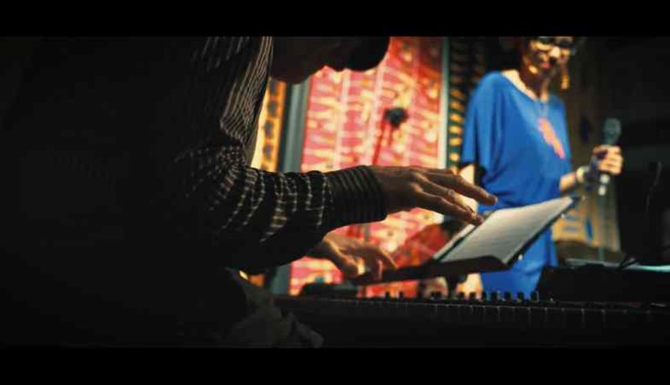 Tom Unwin, a pianist, with singer Mama Tokus in the background