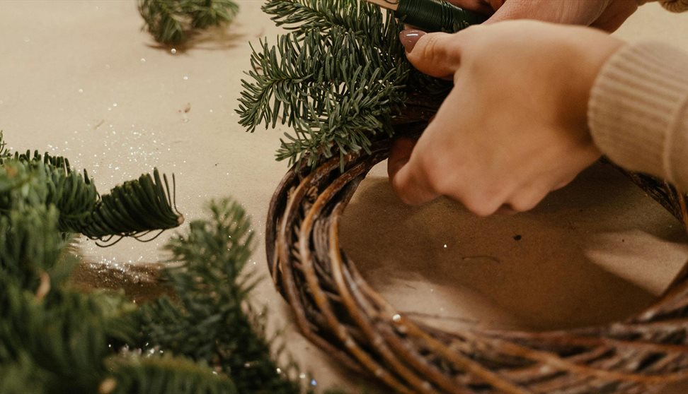 A person making a yule wreath