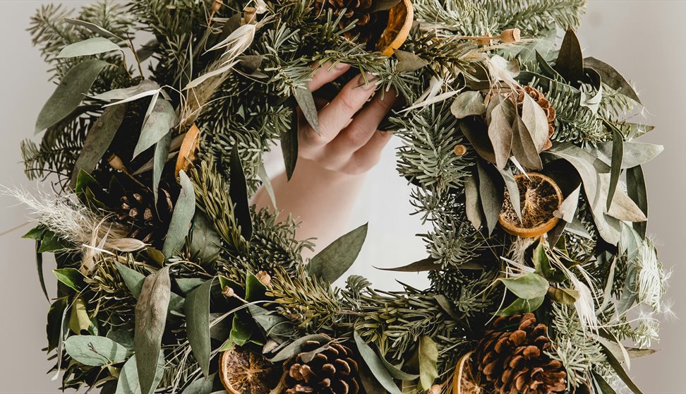 a person holding a wreath