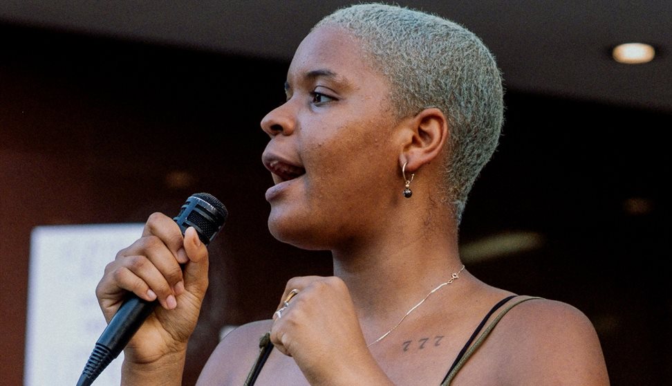 Woman with microphone. Photo Credit: Aiden Craver