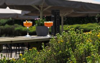 The outdoor terrace at Fishbone Restaurant, with benches, tables and chairs and giant umbrellas