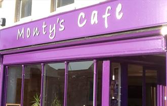 The purple shop front of Monty's showing large windows and the café name.